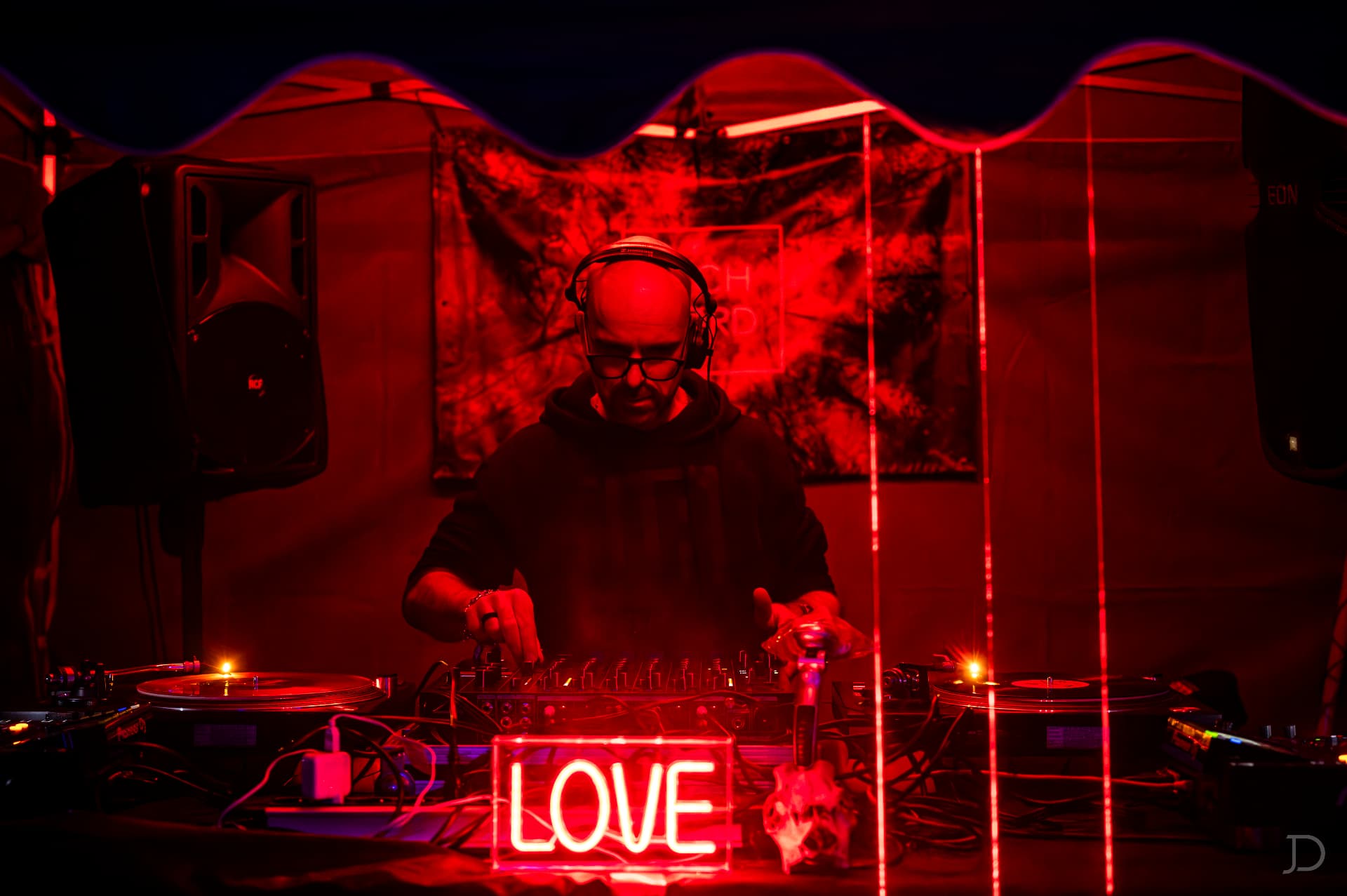 DJ za gramofony s neonovým nápisem LOVE